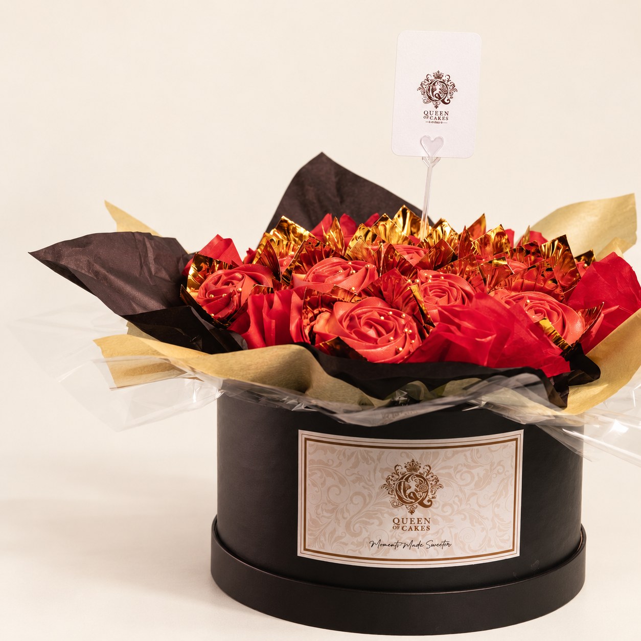 Red rose-piped cupcakes and roses arranged in a Queen of Cakes gift hatbox